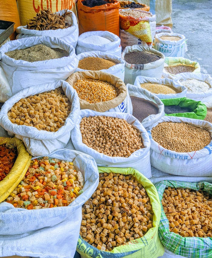 Vibrant display of assorted grains and seeds in open market sacks. Perfect for culinary and travel themes.